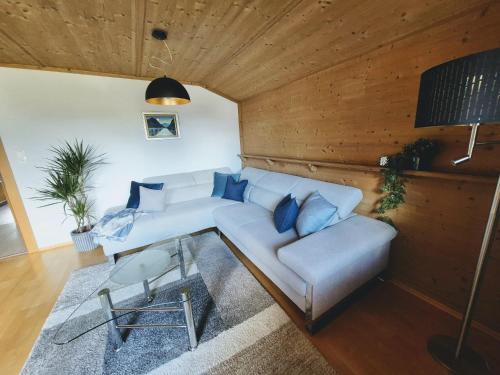 a living room with a white couch and blue pillows at Mondschein Apart in Pertisau