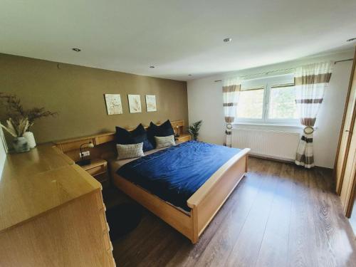 a bedroom with a bed with blue sheets and a window at Mondschein Apart in Pertisau