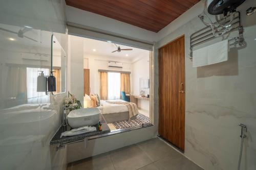 バラナシにあるKaashin - A Boutique Stayのバスルーム(バスタブ、シンク付)、ベッドルーム1室が備わります。
