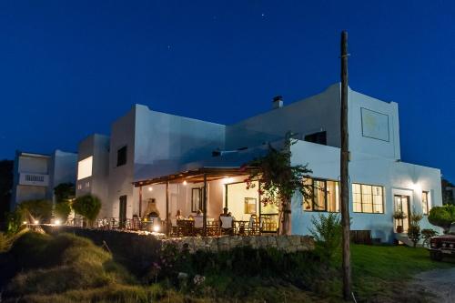 a white house with lights on at night at Ilios and Irene in Mastichari