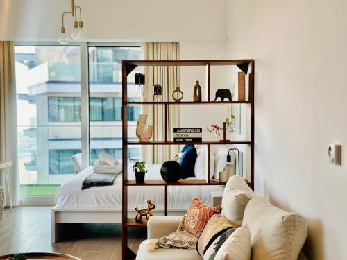 a living room with a book shelf and a couch at Tranquil Yas Retreat Modern Mayan 3 Studio in Abu Dhabi