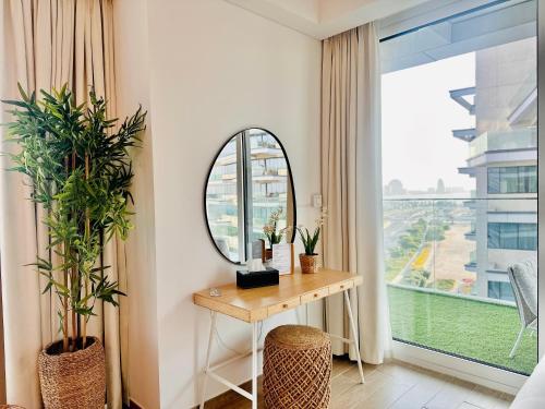 a dressing table and mirror in a room with a window at Tranquil Yas Retreat Modern Mayan 3 Studio in Abu Dhabi
