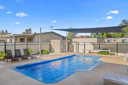 a swimming pool in a yard with a fence at Alice Village in Alice Springs