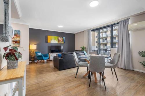 a living room with a table and a couch at East Perth Escape WiFi Parking in Perth