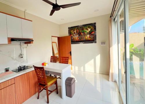 a kitchen with a table and a ceiling fan at salkhahouse bali cliff one in Ungasan