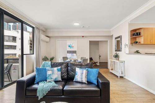 a living room with a leather couch and a table at East Perth Escape WiFi Parking in Perth