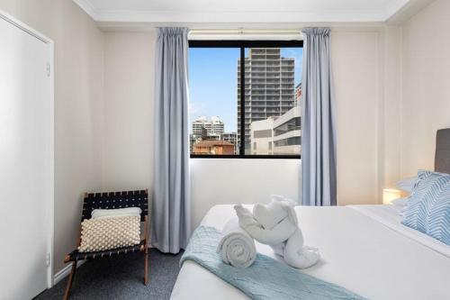a bedroom with a bed with a teddy bear on it at East Perth Escape WiFi Parking in Perth