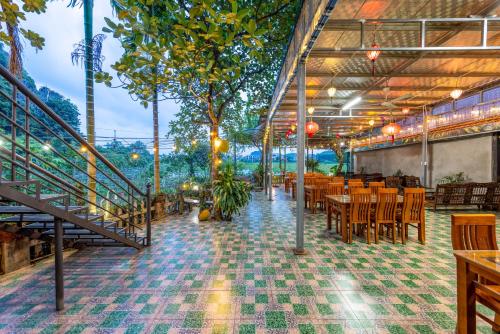 a restaurant with tables and chairs and a staircase at Eco Field Nest Tam Coc in Ninh Binh