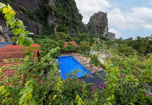 a resort with a swimming pool in front of a mountain at Tam Coc Eco Field Nest By ANMS GROUP in Ninh Binh