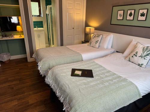 two beds in a hotel room with a tray on them at The Farmers Boy Inn Guest House in Longhope