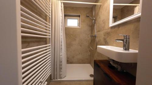 a bathroom with a shower and a sink and a tub at Ferienwohnung Zirbenzapfen in Judenburg