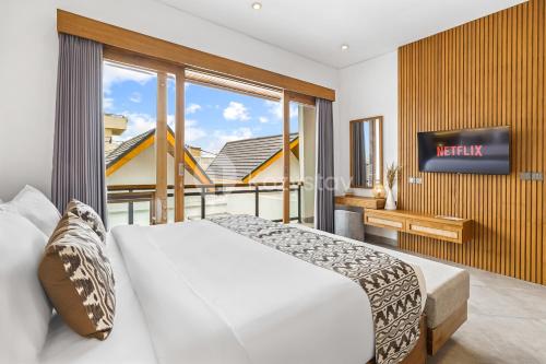 ein Schlafzimmer mit einem Bett und einem Fernseher an der Wand in der Unterkunft Oslen Villa by Kozystay - Canggu in Dalung