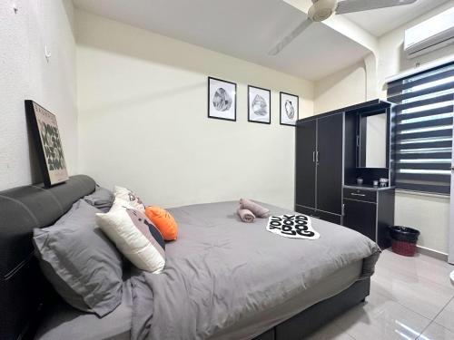 a bedroom with a bed with pillows on it at Specious Living Cozy House in Bukit Mertajam