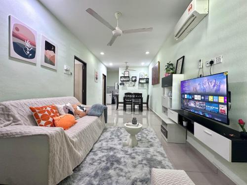 a living room with a couch and a flat screen tv at Specious Living Cozy House in Bukit Mertajam