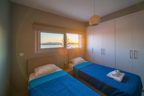 a bedroom with two beds and a window with the ocean at Majestic Sunset Salt Lake Views 300m from beach in Larnaca