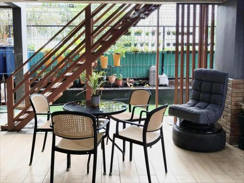 a patio with a table and chairs and a staircase at Casa Andrea Bella in Bacolod