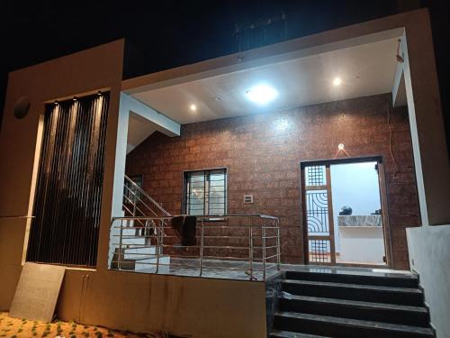 a building with a staircase and a brick wall at NANDANAVANA Homestay in New Hampi