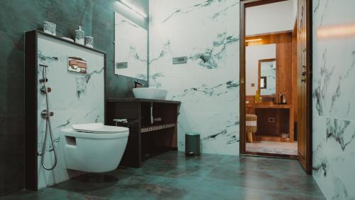 a bathroom with a toilet and a sink at The Wild Rest Nature Resort in Avathi
