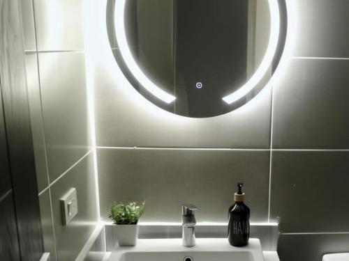 a bathroom with a sink with a round mirror at Salty Life Chalet, Azha in Ain Sokhna