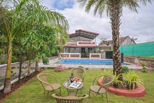 a villa with a swimming pool and palm trees at Rustic Lakeside Private Escape With Huge Private Pool 2min From Lake in Lonavala