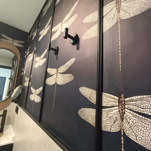 a bathroom with butterflies painted on the wall at El Jardín de las Libélulas in Coria