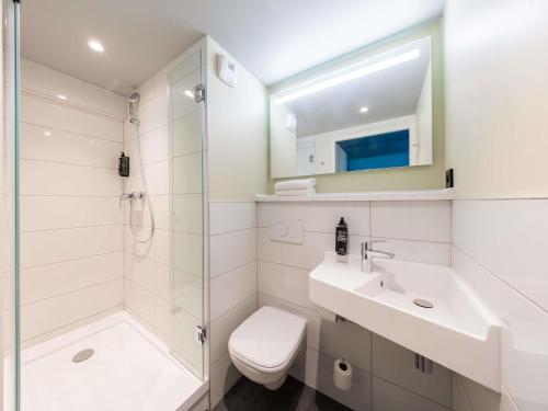 a bathroom with a sink and a toilet and a shower at Ibis budget Béziers Est Mediterranée A9 / A75 in Béziers