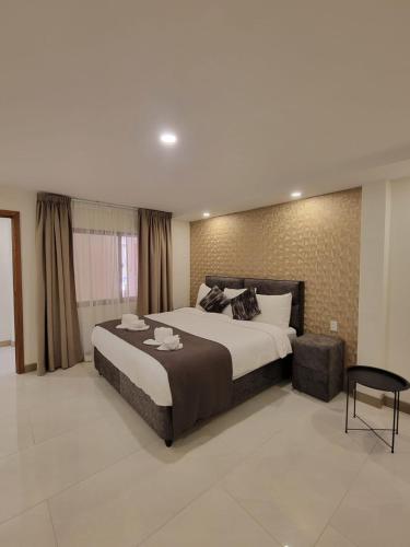 a large bedroom with a large bed and a chair at Hotel Rizuna by empire in Paramaribo