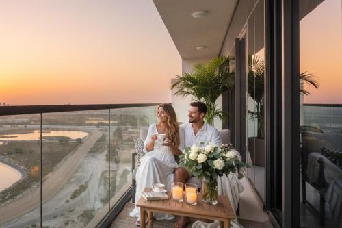 a bride and groom sitting on the balcony of a hotel at Keyrock Aykon Tower, Business Bay - Pool & Gym in Dubai