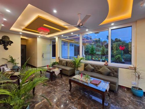a living room with couches and a large window at Amoda - Best Hotel in Dharamshala in Dharamshala