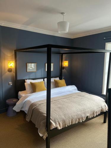 a bedroom with a large bed with yellow pillows at The Boyne Arms in Burwarton