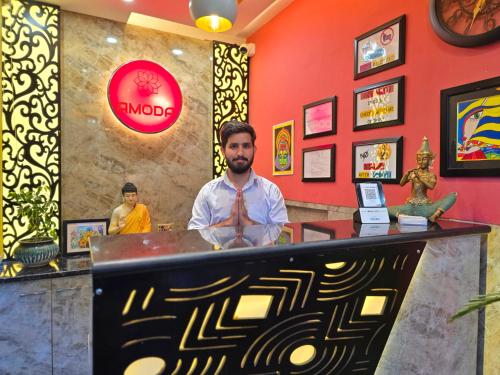 a man standing behind a counter in a restaurant at Amoda - Best Hotel in Dharamshala in Dharamshala