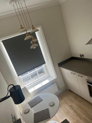 a small kitchen with a white table and a window at The Boyne Arms in Burwarton
