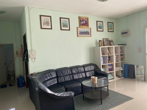 a living room with a leather couch and a table at Garden house in Ban Krok Khi Nu