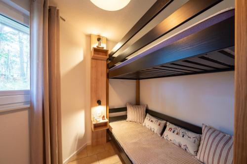 a room with a bunk bed in a room at Ferienhaus Tipi 365 - strandnahes Ferienhäuschen mit Terrasse und kostenfreier Nutzung des AHOI!-Schwimmbades in Sellin in Göhren