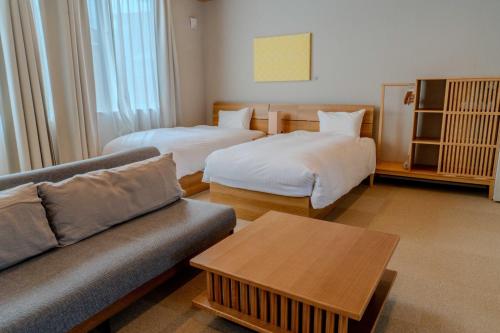 a living room with two beds and a couch at Ginkgo House ギンコハウス in Fujiyoshida
