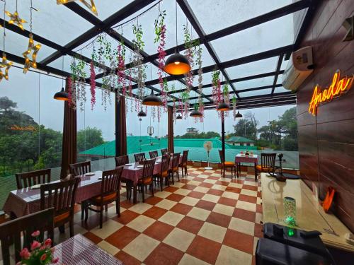 a restaurant with tables and chairs and a view of the water at Amoda - Best Hotel in Dharamshala in Dharamshala