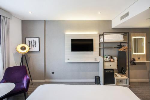 a hotel room with a bed and a tv at Premier Inn Abu Dhabi Capital Centre in Abu Dhabi