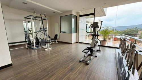 a gym with treadmills and exercise bikes in a room at Hotel Mahendra, Karad in Karad