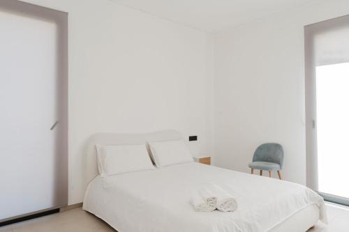 a bedroom with a white bed and a chair at Gc Luxury Apartments e Spa in Santa Margherita di Belice