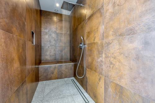 a bathroom with a shower with wooden walls at Contemporary Villa Nada with Pool and Sauna in Tinjan