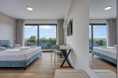 a bedroom with two beds and a table with a desk at Contemporary Villa Nada with Pool and Sauna in Tinjan