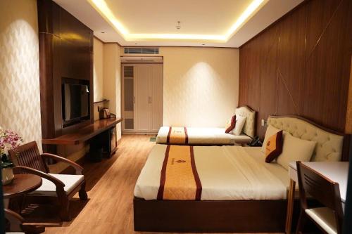 a hotel room with two beds and a television at Thảo Ngân Pleiku Hotel in Plei Khưn