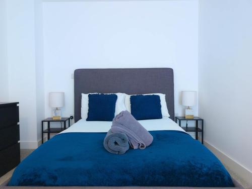 ヘメル・ヘムステッドにあるHemel Apartments - LuxeStayのベッドルーム1室(ブルーベッド1台、タオル付)