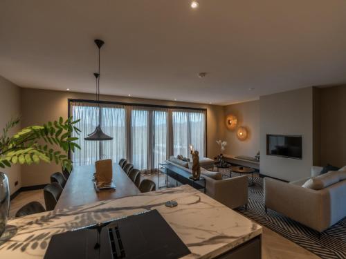 a living room with a table and chairs and a television at Modern villa in De Cocksdorp near the beach in De Cocksdorp