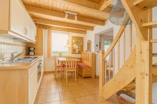 a kitchen with a staircase leading to a dining room at Lüttjes Diekhuus in Butjadingen OT Tossens