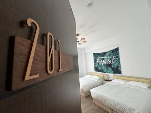 a room with two beds and a sign on the wall at 夏茉二館包棟民宿 in Magong