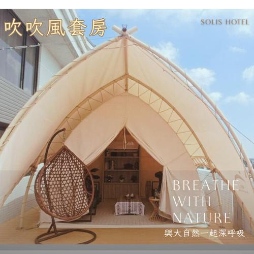 una tenda con una sedia di vimini all'interno di 金金禮寓Solis hotel a Jinhu