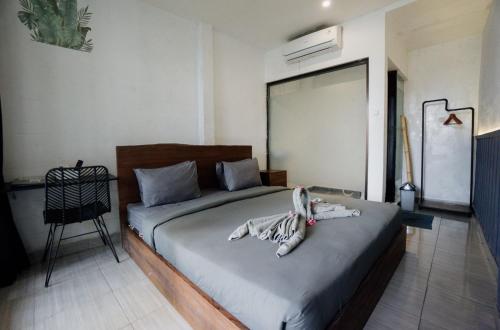 een slaapkamer met een bed in een kamer met een ventilator bij Escotel Vanili Guest House in Canggu