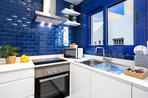 eine blaue Küche mit einer Spüle und einem Herd in der Unterkunft Playa Jardín Sun & Dreams in Puerto de la Cruz