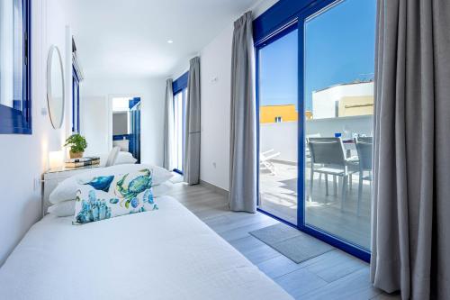 ein Schlafzimmer mit einem Bett und einem großen Glasfenster in der Unterkunft Playa Jardín Sun & Dreams in Puerto de la Cruz